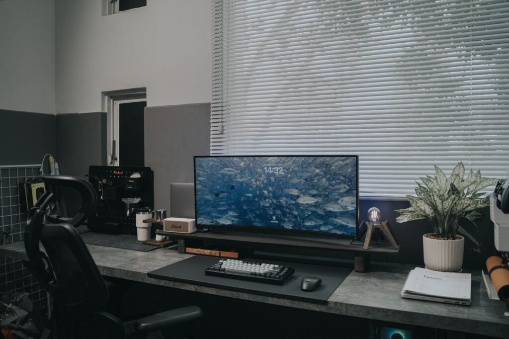 A desk with a monitor placed at a right angle to a window to reduce glare