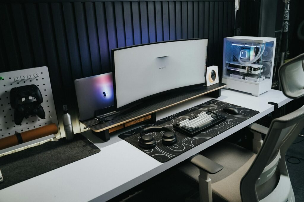 A desktop PC tower raised on a small stand beside a desk instead of sitting on carpet.