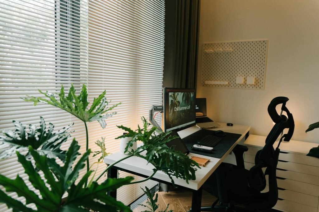 Person adjusting a home office chair and monitor at a clean desk