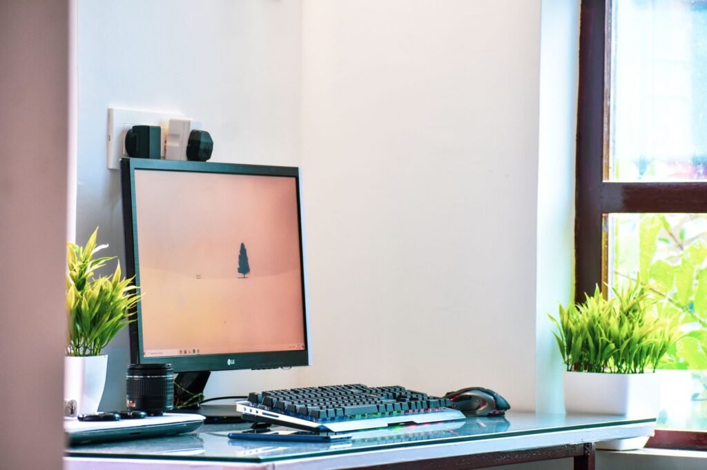 A modest desk setup with a monitor on a riser, a basic keyboard, and minimal accessories.