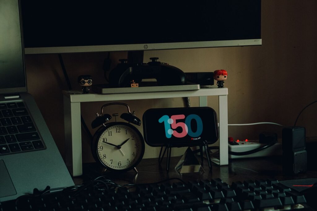 A laptop connected to an external monitor through a dock on a home office desk