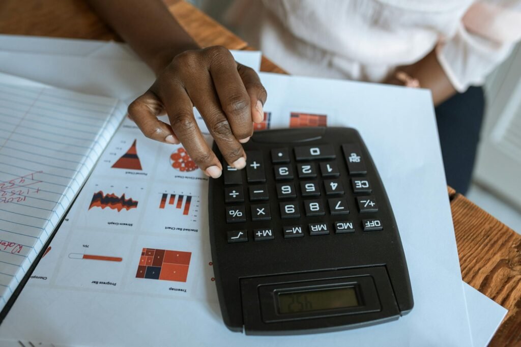 A calculator, receipts, and a notebook with a small desk upgrade budget written down.
