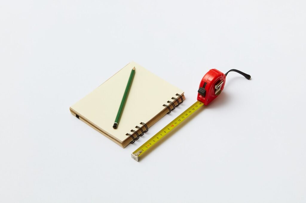 Overhead view of a desk with a checklist and measuring tape for workstation adjustments