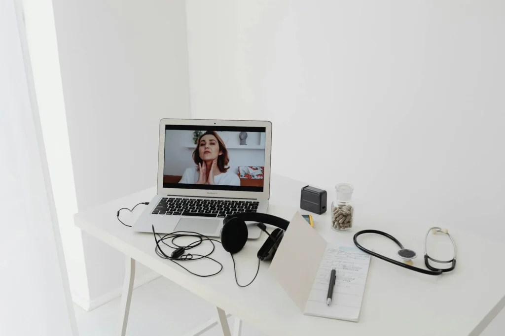 A laptop on a desk with headphones and accessories arranged for a quick hardware test.