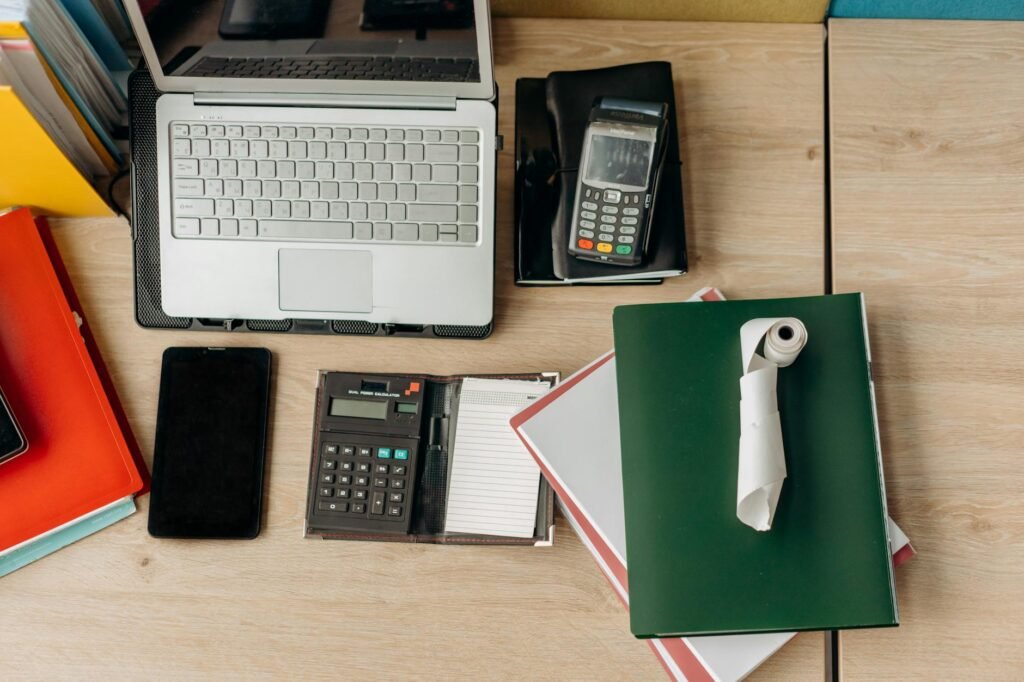 Receipts, a calculator, and several monitor cables on a desk