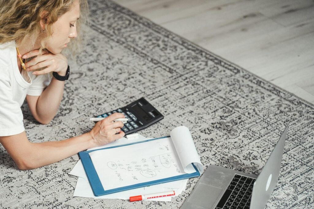 A desk with a notebook, calculator, and monitor setup planning notes