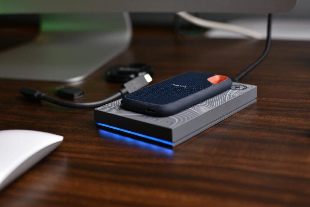 A new laptop on a tidy desk beside a notebook and external drive