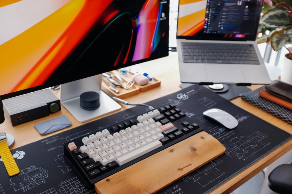 A laptop raised on a stand with an external keyboard and mouse below it
