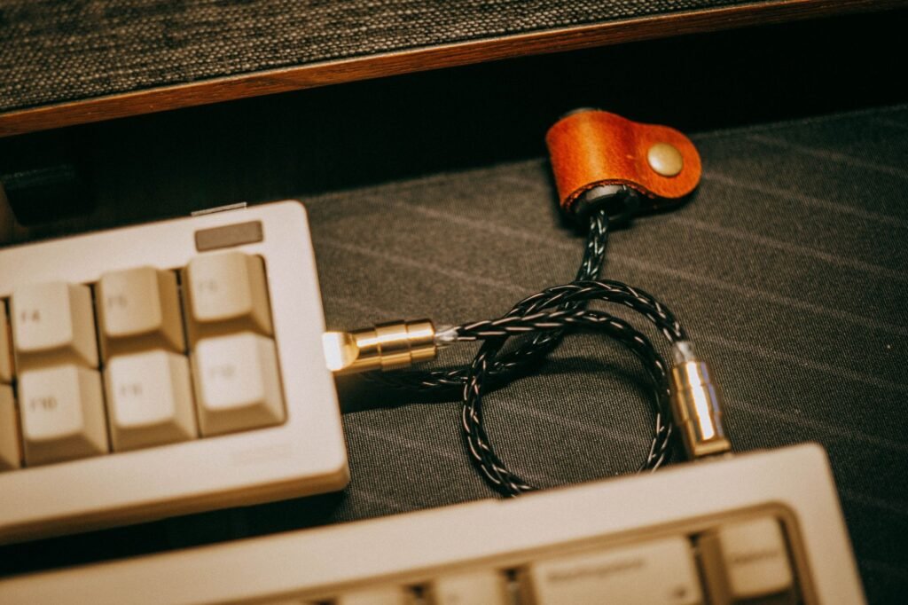 Under a desk, a mounted cable tray holds a power strip and neatly routed PC cables.