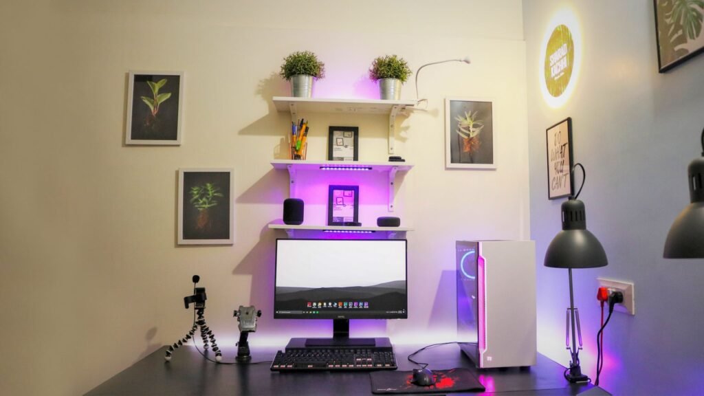 A clean desk with one monitor, keyboard, mouse, notebook, and lamp