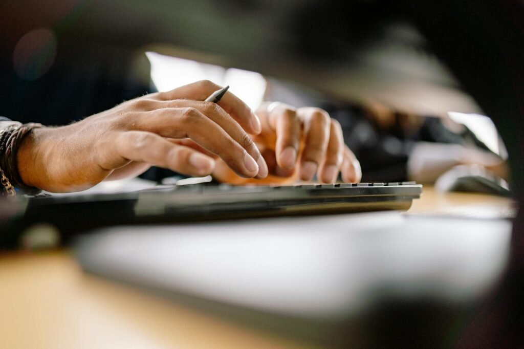 Hands typing with straight wrists and a mouse positioned beside the keyboard