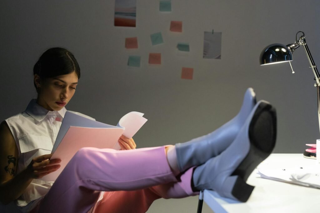 Feet resting on a footrest under a desk while seated at a workstation