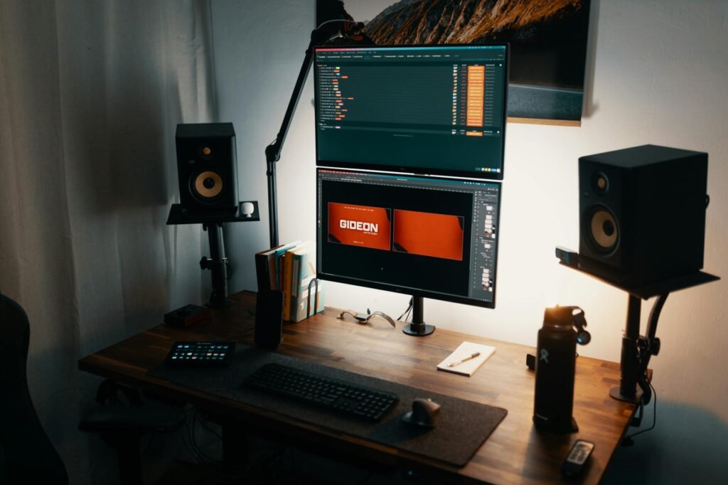 A dual-monitor setup viewed from behind with cables routed neatly along the monitor arms and desk edge.